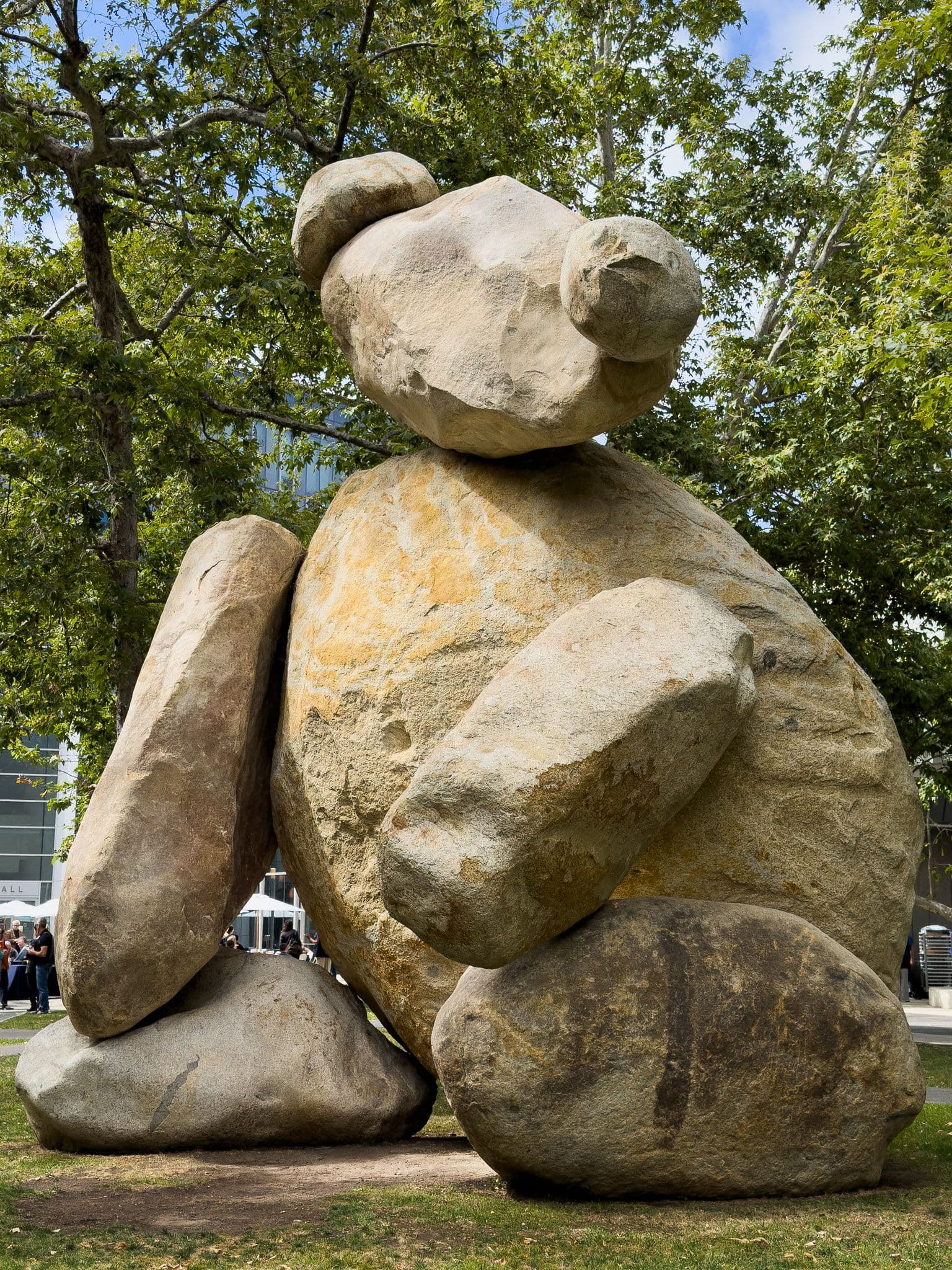 Large stone bear sculpture surrounded by trees